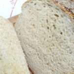 Sourdough Bread that has been sliced on a wooden cutting board.