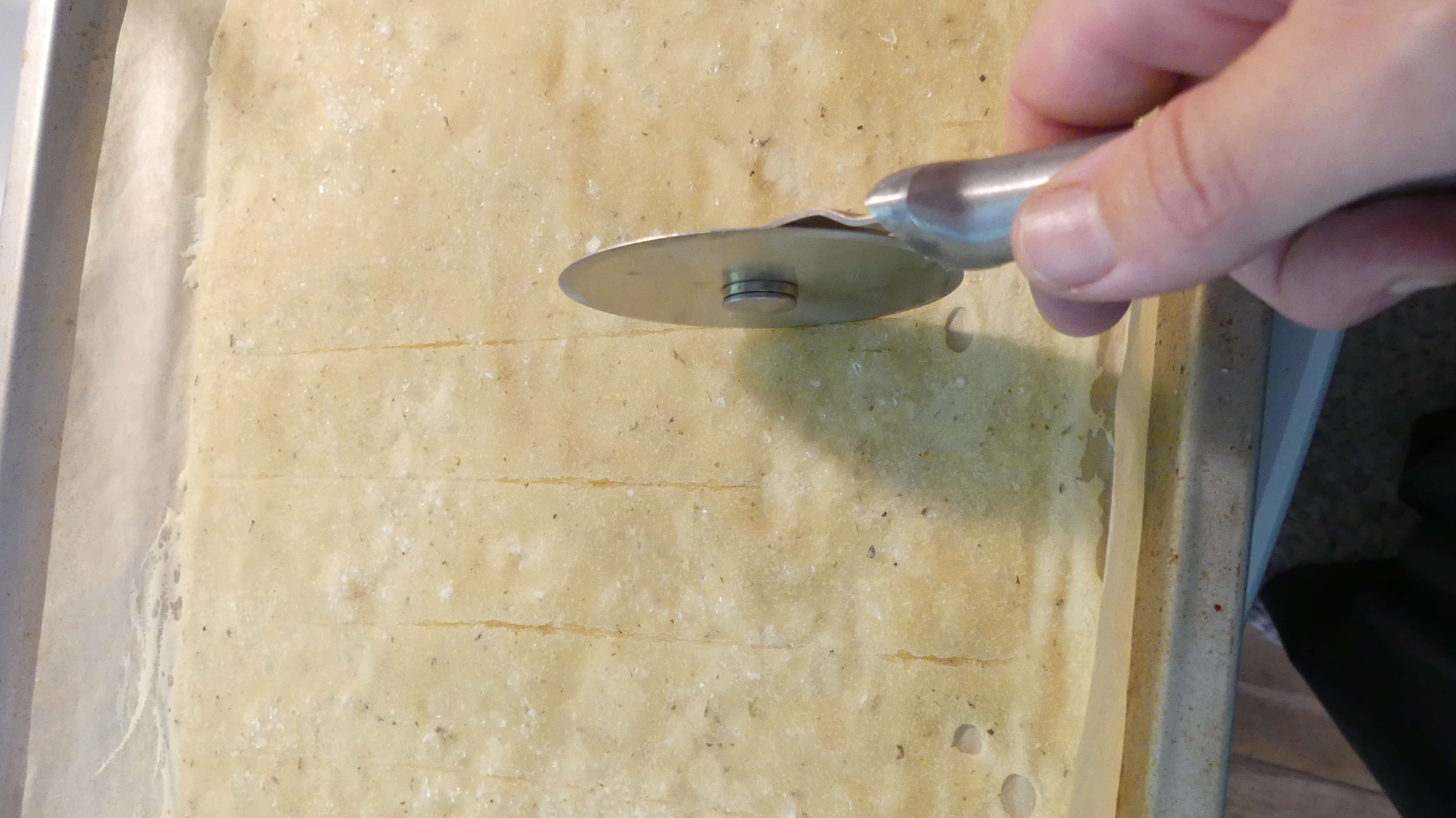 cutting the sourdough discard cracker dough after it has been in the oven for 10 minutes