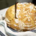 loaf of artisan bread on a striped blue kitchen towel