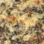 The sourdough taco pizza is laying on a white table with a blue and white towel to the side.