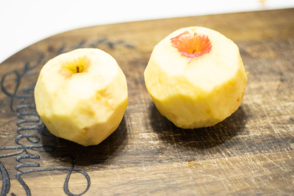 2 peeled apples on a cutting board