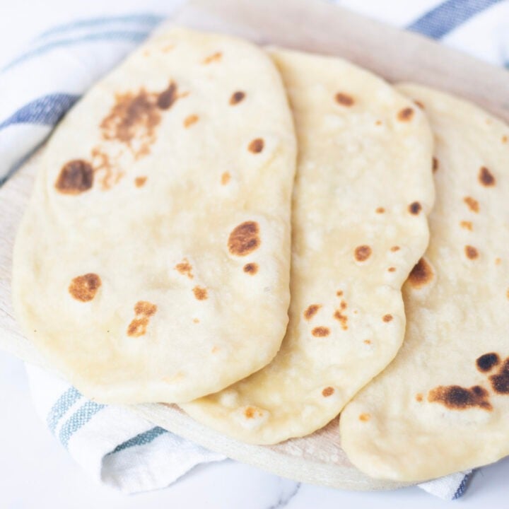 naan on cutting board with blue and white towel underneath