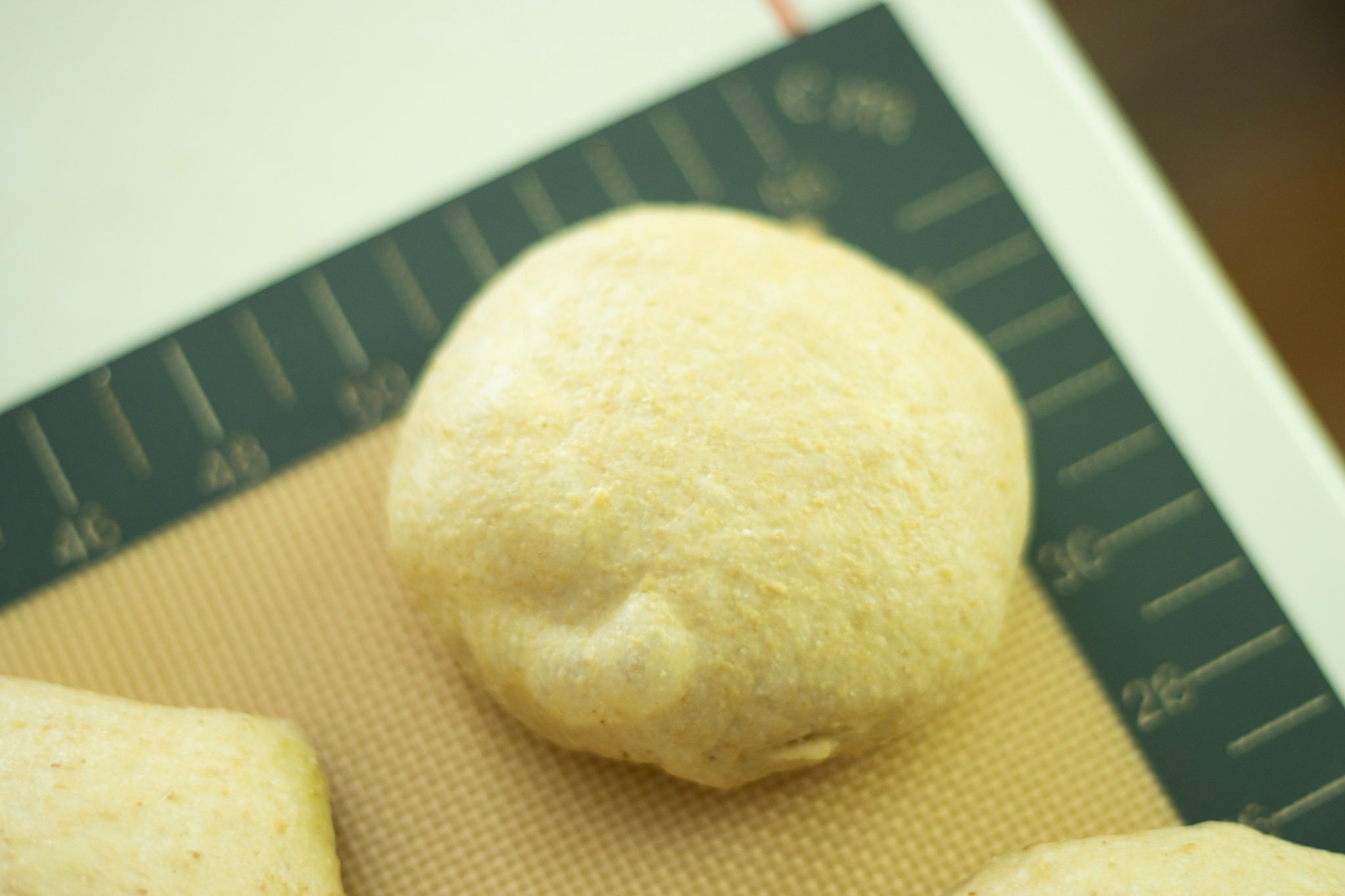 sourdough pretzel bun that has proofed and has bubbles on the surface of the dough
