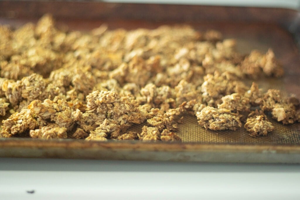 baked sourdough granola cooling on baking sheet