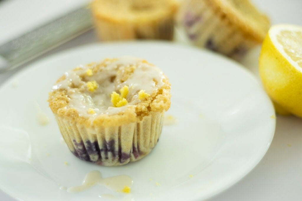 blueberry cupcake on plate with cupcakes in background and a lemon half