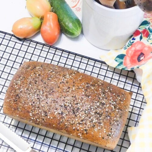 loaf of bread with fresh garden veggies in the background