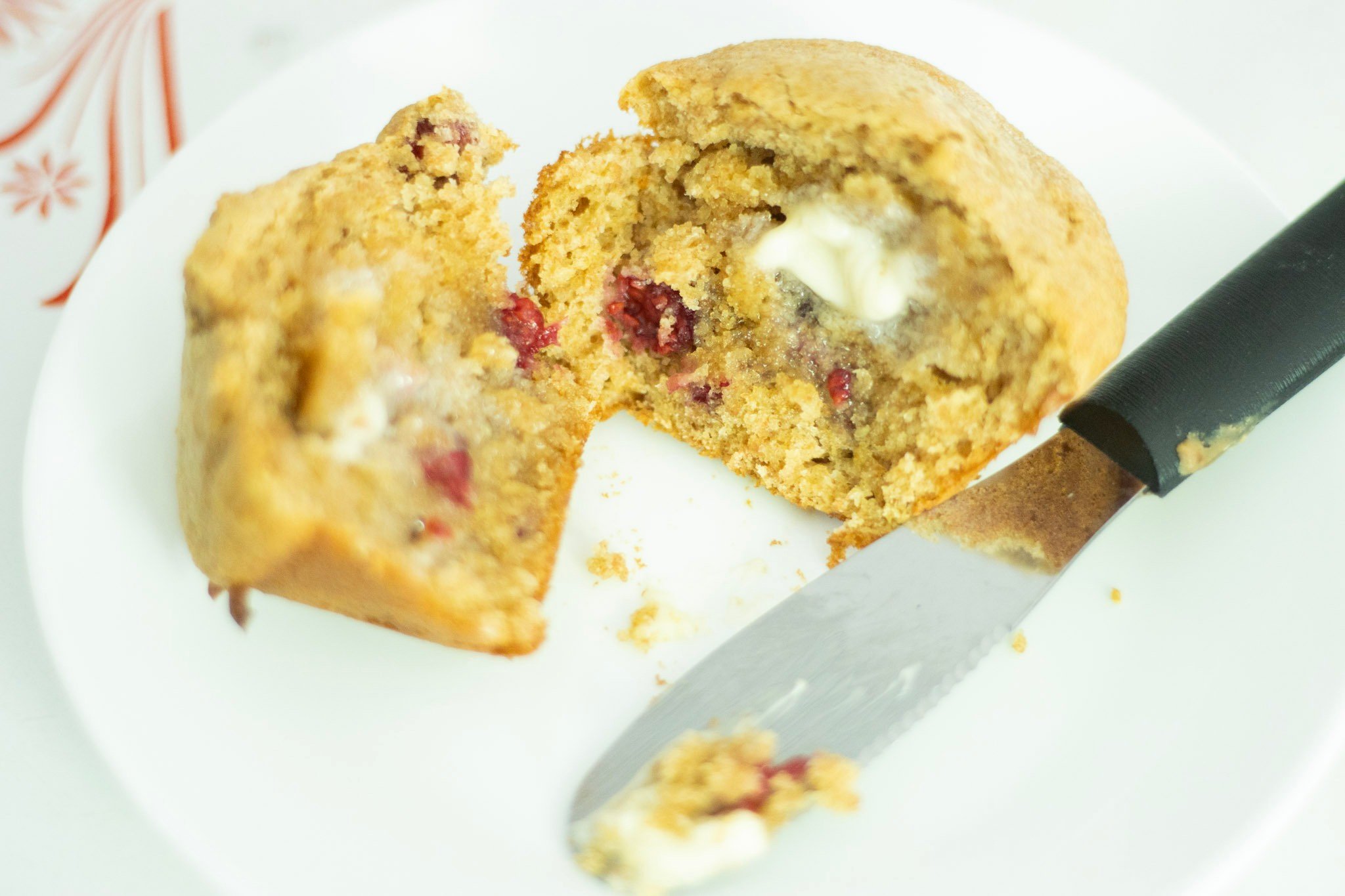 sourdough raspberry muffin cut in 2 with butter spread on each side