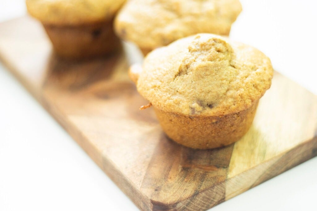 sourdough discard raspberry muffins on a small cutting board