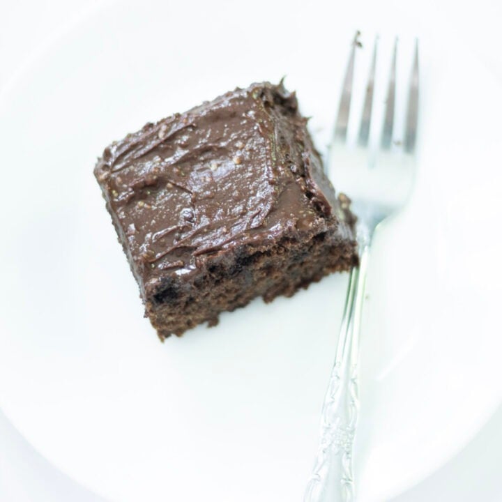 slice of sourdough chocolate cake on a white plate with a fork beside the cake