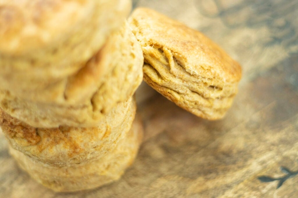 sourdough cat head biscuits stacked on a cutting board