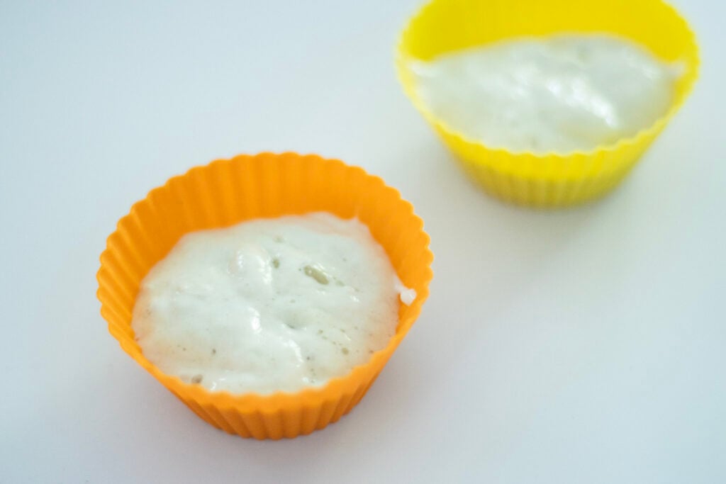 2 silicone muffin cups with sourdough starter in them.