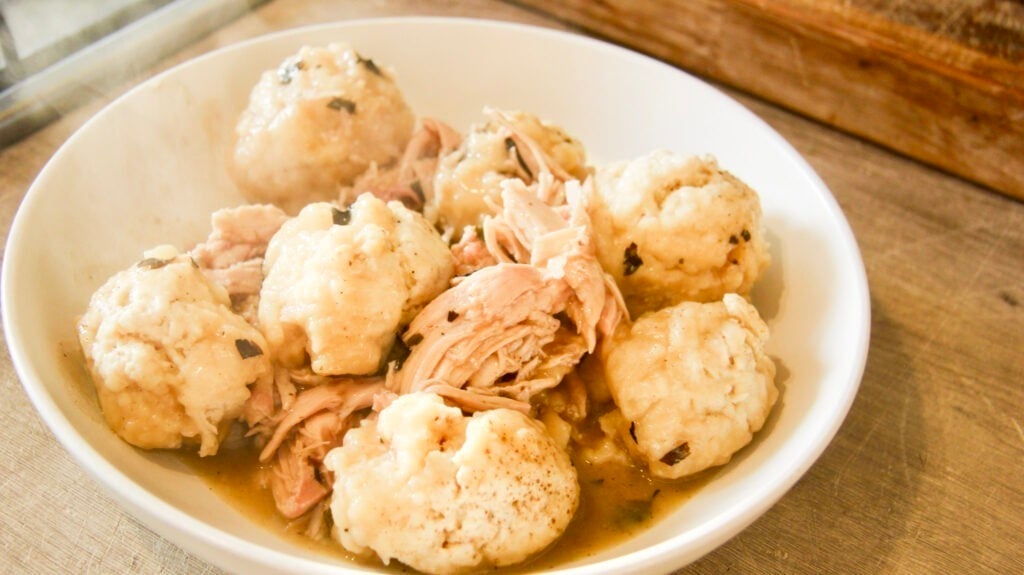 a white bowl of chicken and dumplings