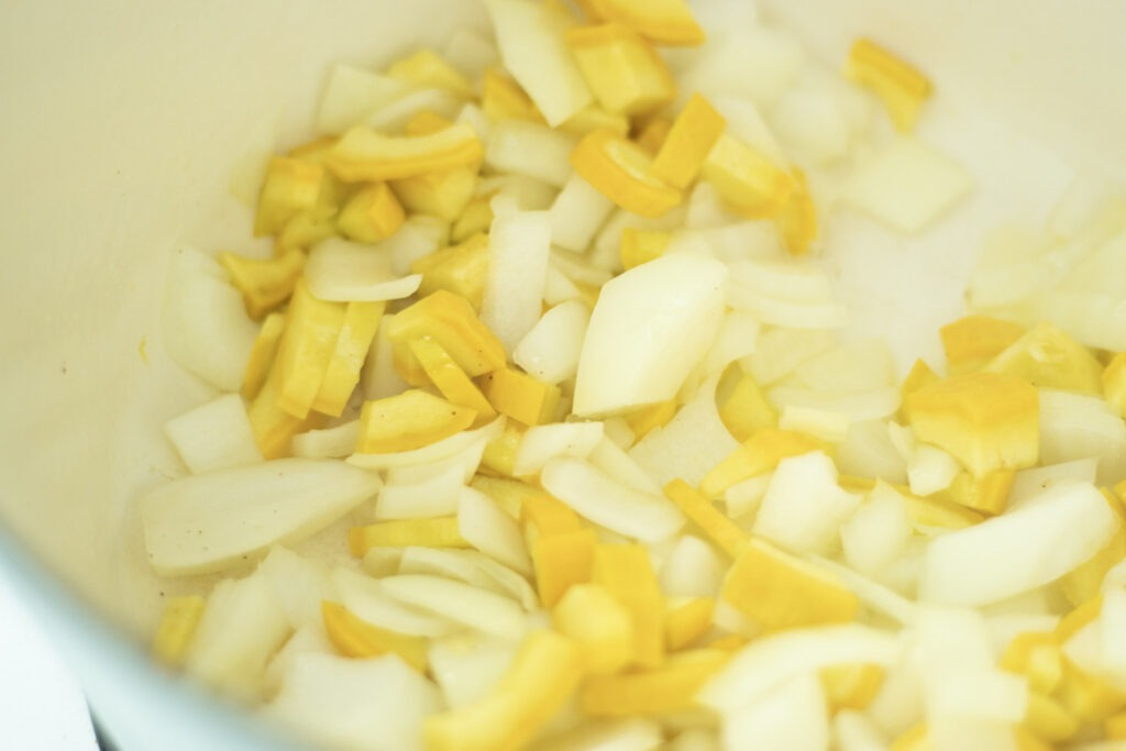 Yellow squash and onion sauteing in large pot