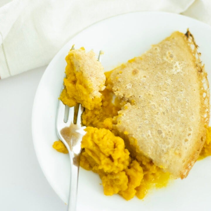 shot of sourdough pumpkin cobbler on a white plate with a fork
