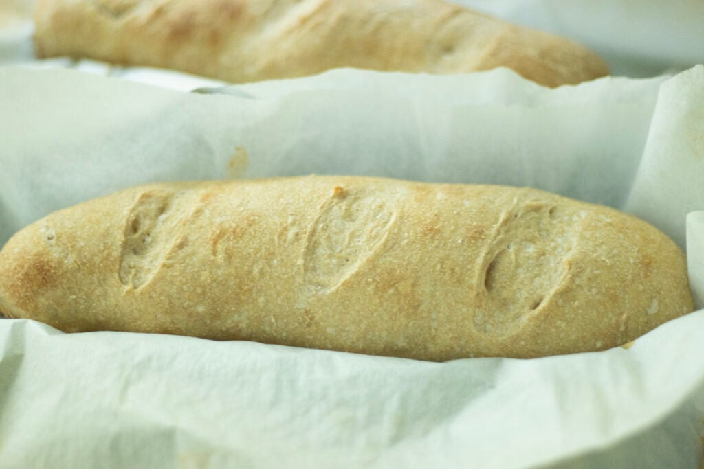 sourdough baguettes just out of the oven on parchment paper