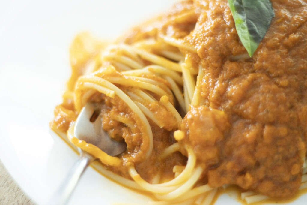 Roasted tomato sauce over spaghetti with fork that has twirled noodles on it