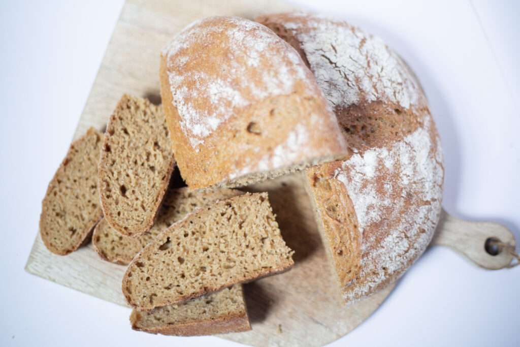 overhead shot of sourdough einkorn bread some of which has been sliced to show the crumb