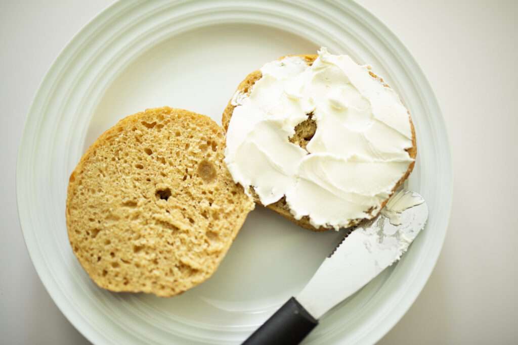 overhead shot of sourdough pumpkin bagel spread with cream cheese