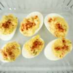 overhead shot of deviled eggs in a glass dish