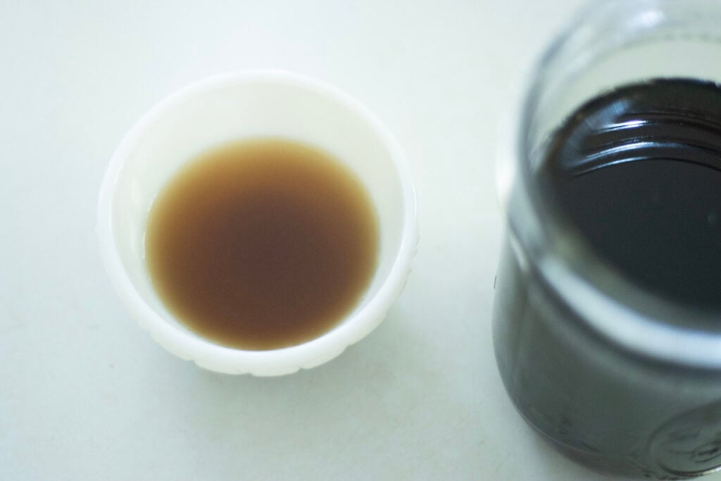 white bowl with homemade pancake syrup and a jar beside it