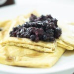 sourdough crepes on a plate folded with berries on top