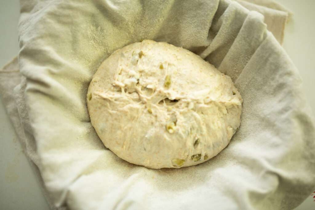 sourdough jalapeno cheddar dough in a proofing basket