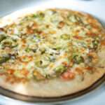 This is a shot of a sourdough pizza with the evening sunlight glaring on top