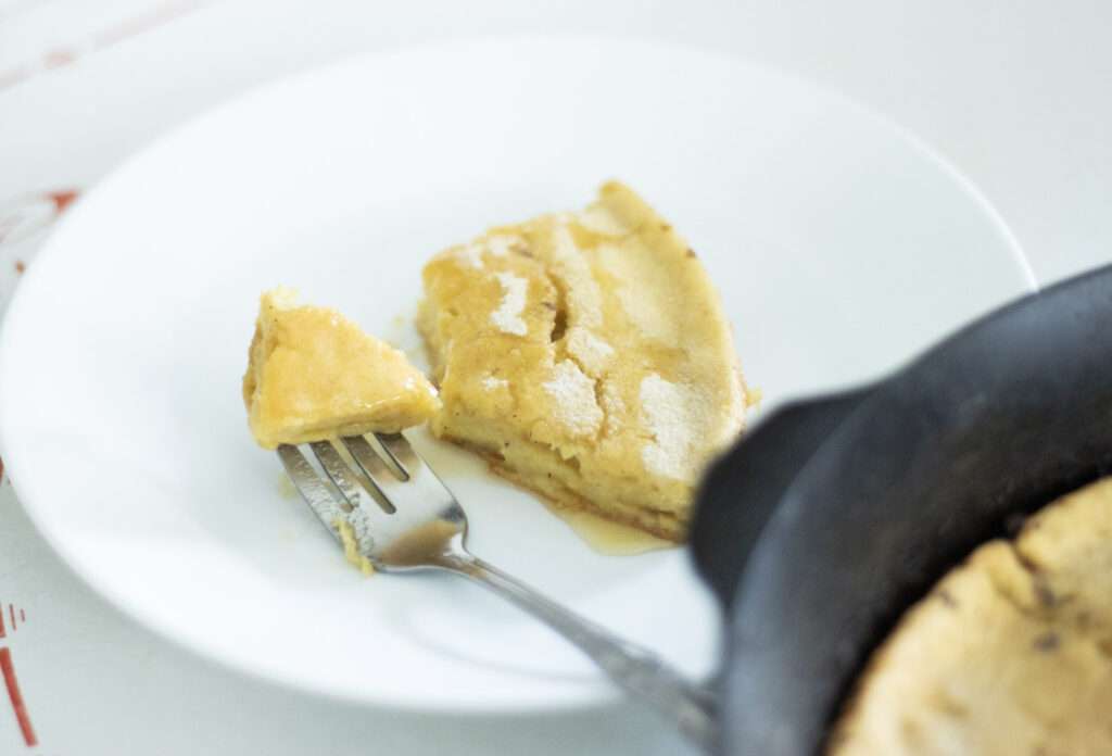 a slice of sourdough dutch baby pancake with a fork on a plate