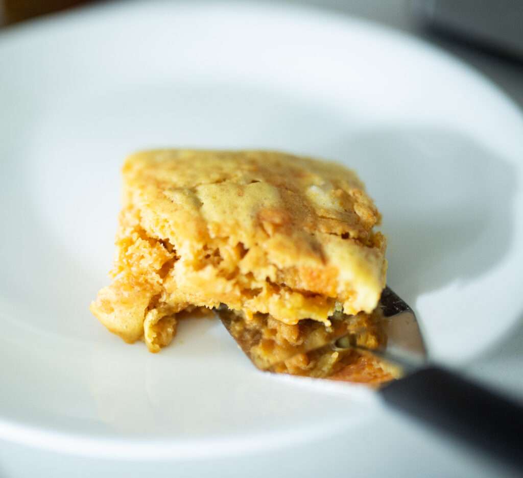 close shot of slice of sourdough sweet potato casserole on white plate