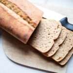 overhead pic of kneaded sourdough bread sliced on a cutting board