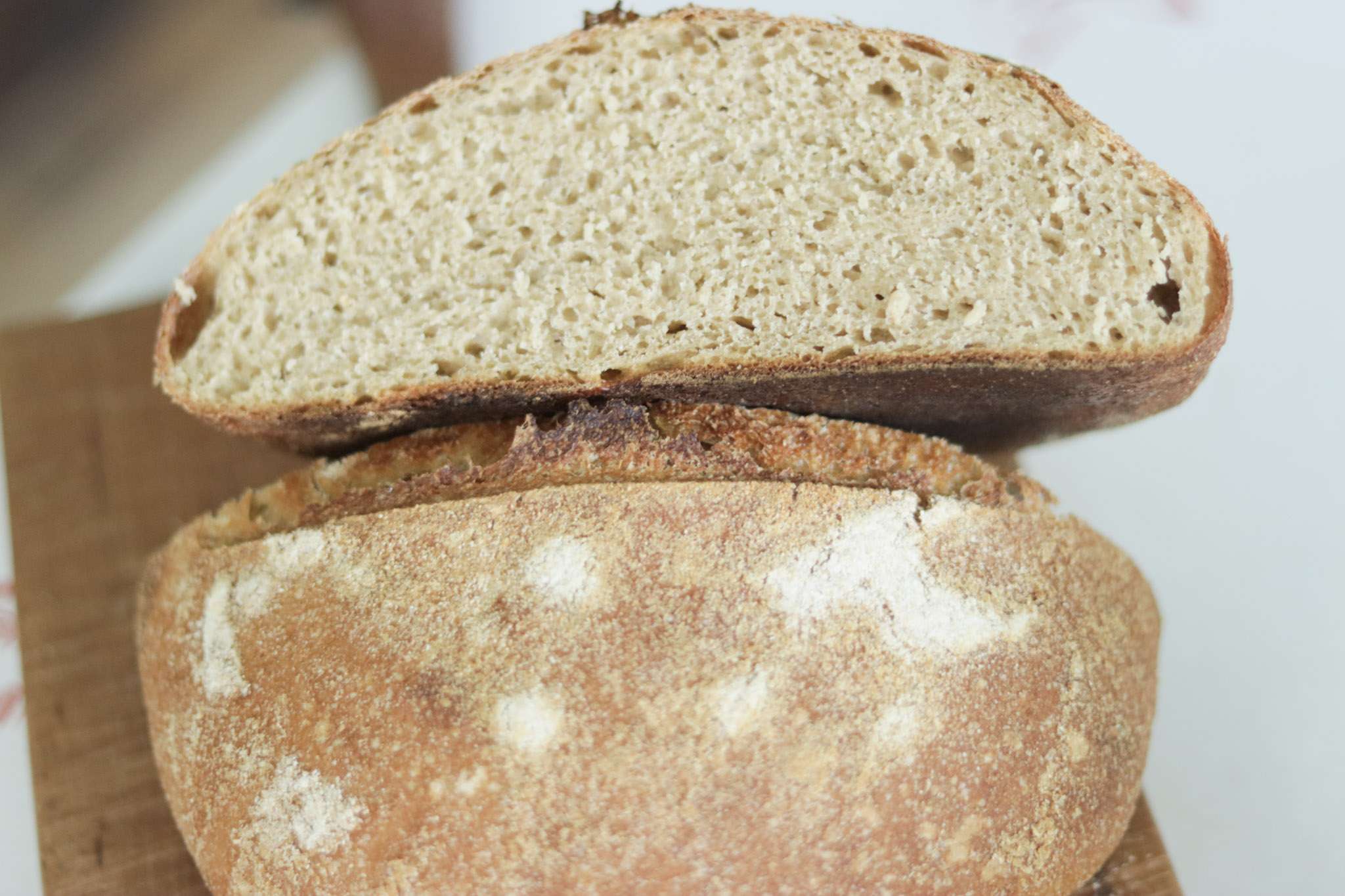 Whole grain rustic sourdough loaf sliced in half to show crumb