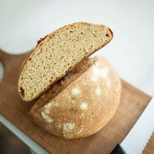 Overhead photo of rustic whole grain sourdough loaf cut in half