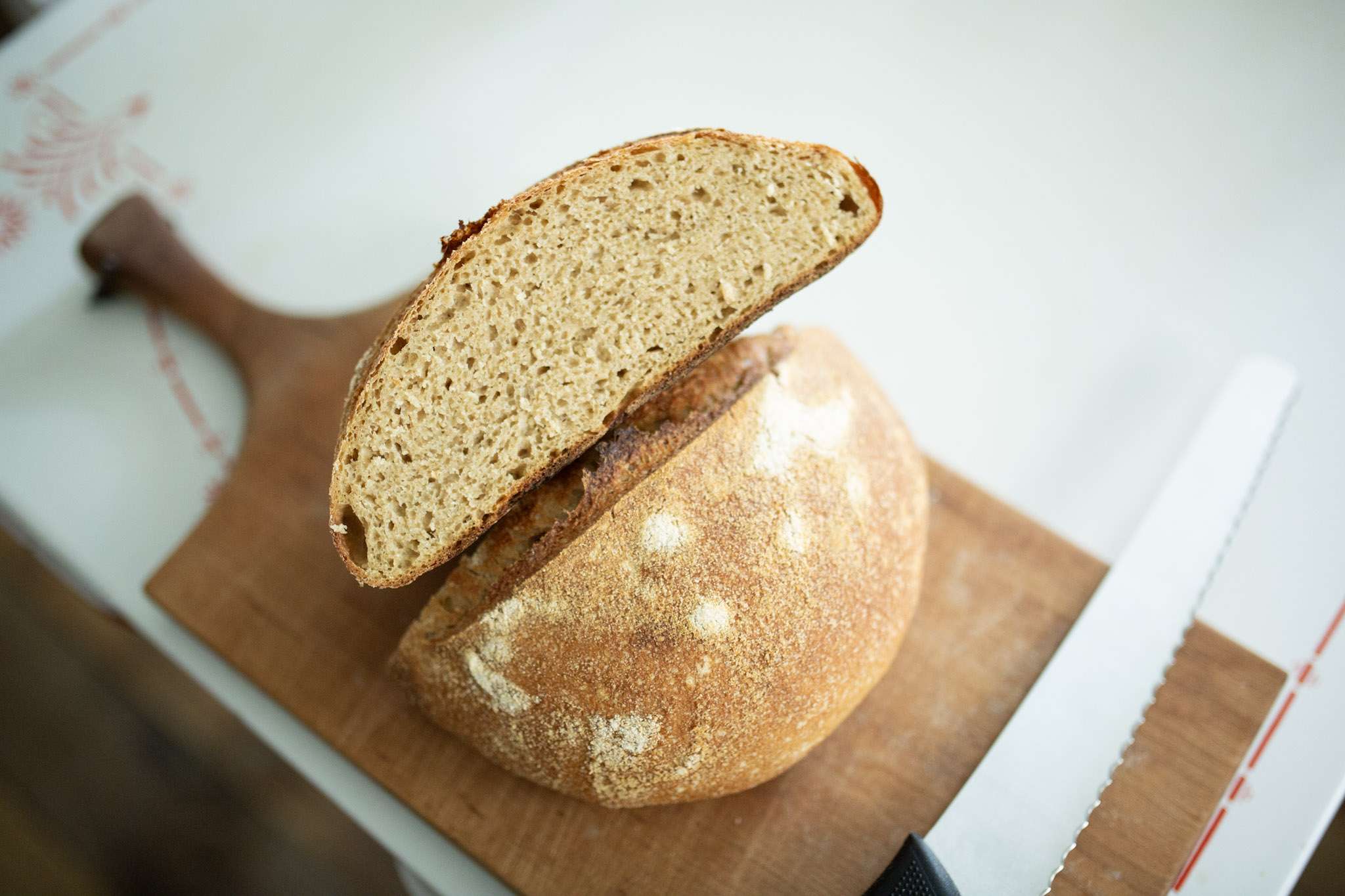 Overhead photo of rustic whole grain sourdough loaf cut in half