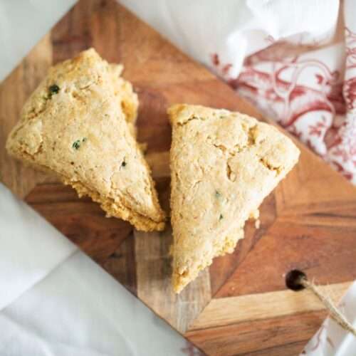 overhead shot of 2 sourdough jalapeno garlic scones on a board over a red and white towel
