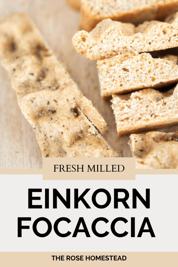 Pinterest pin with a photo of fresh milled einkorn focaccia on a cutting board. Text reads fresh milled einkorn focaccia.