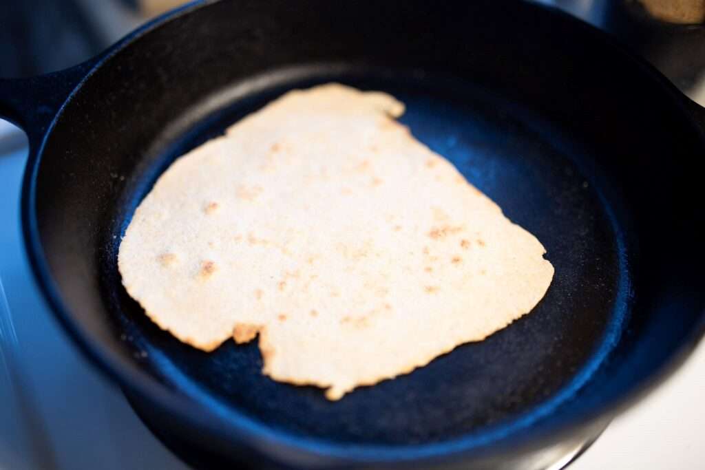 a fresh milled flour tortilla in a cast iron skillet