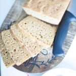 overhead shot of sliced sourdough einkorn sandwich bread on a cutting board with a bread knife