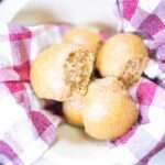 overhead shot of einkorn sourdough dinner rolls in a bowl with a red and white towel