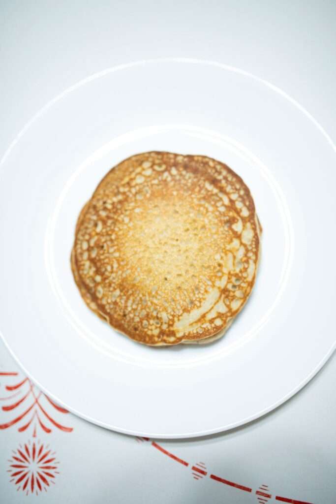 This is a golden brown buckwheat pancake on a white plate.