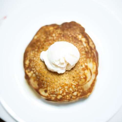 Overhead photo of buckwheat pancakes with a dollup of yogurt on top.
