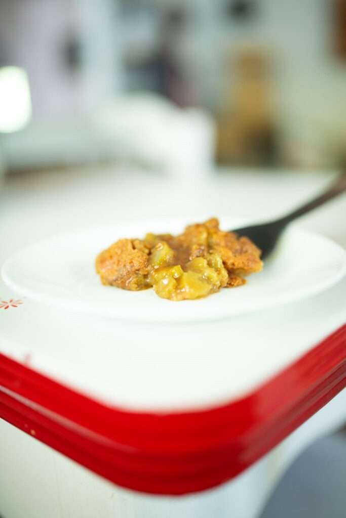 Side view of a serving of sourdough rhubarb cobbler on a white plate
