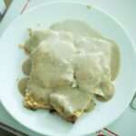 An overhead photo of breakfast gravy over biscuits.