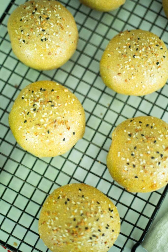 Overhead photo of sourdough hamburger buns on a wire rack.