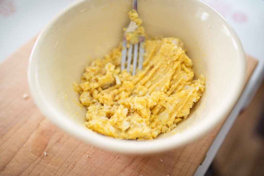 Mashed potato cake dough in a white bowl.