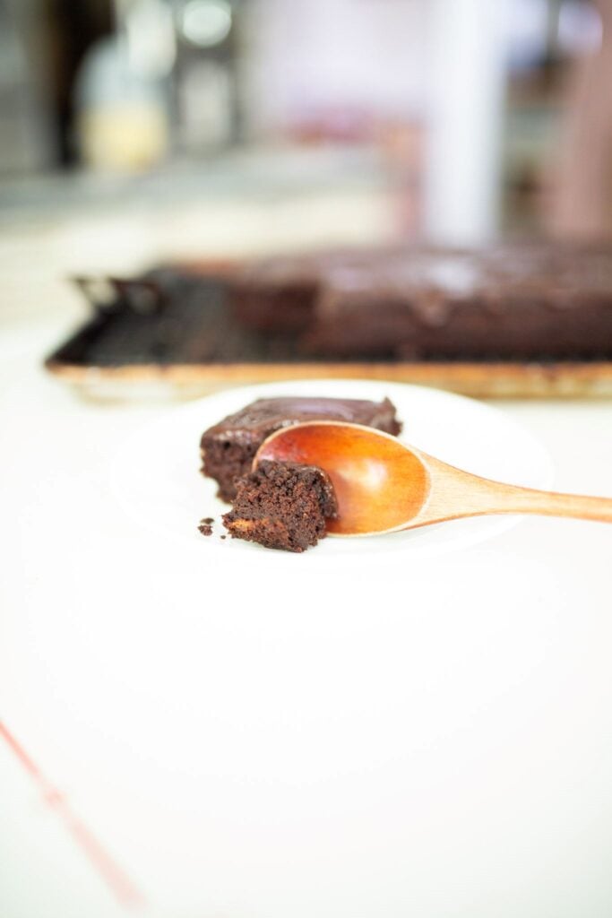 a slice of fresh milled chocolate cake with a piece on a wooden spoon