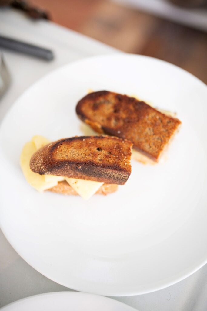 An overhead photo of a sourdough grilled cheese sandwich on a white plate.