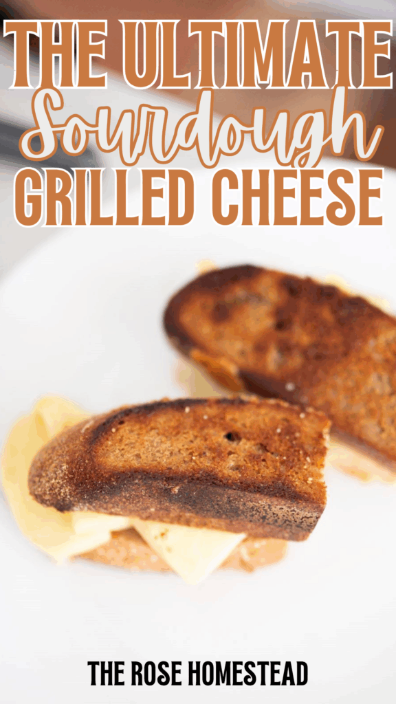 This is a pinterest pin for a sourdough grilled cheese sandwich with a picture of a golden brown grilled cheese with melted cheese on a white plate. The text reads the ultimate sourdough grilled cheese.