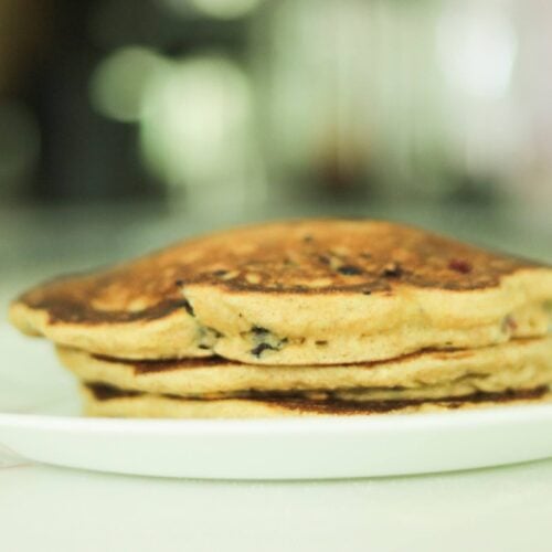 There is a white plate with a stack of einkorn pancakes.
