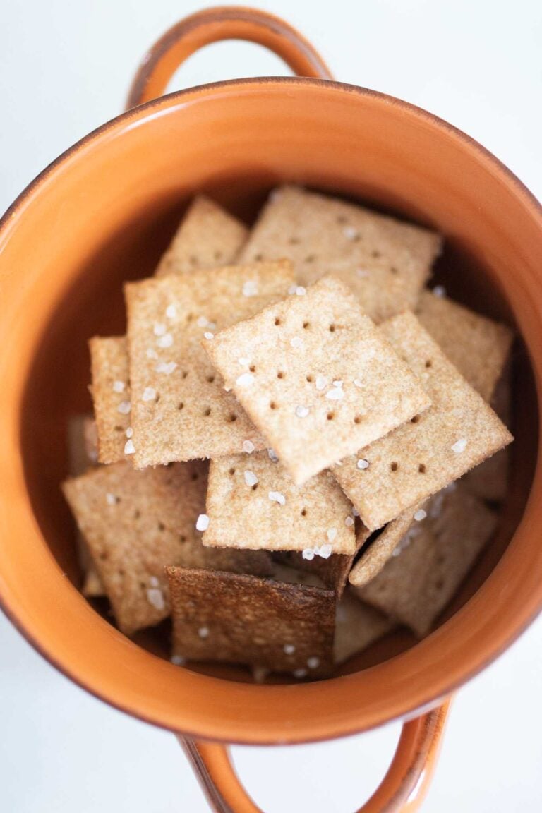 This is an overhead picture of a pile of fresh milled crackers in an orange bowl