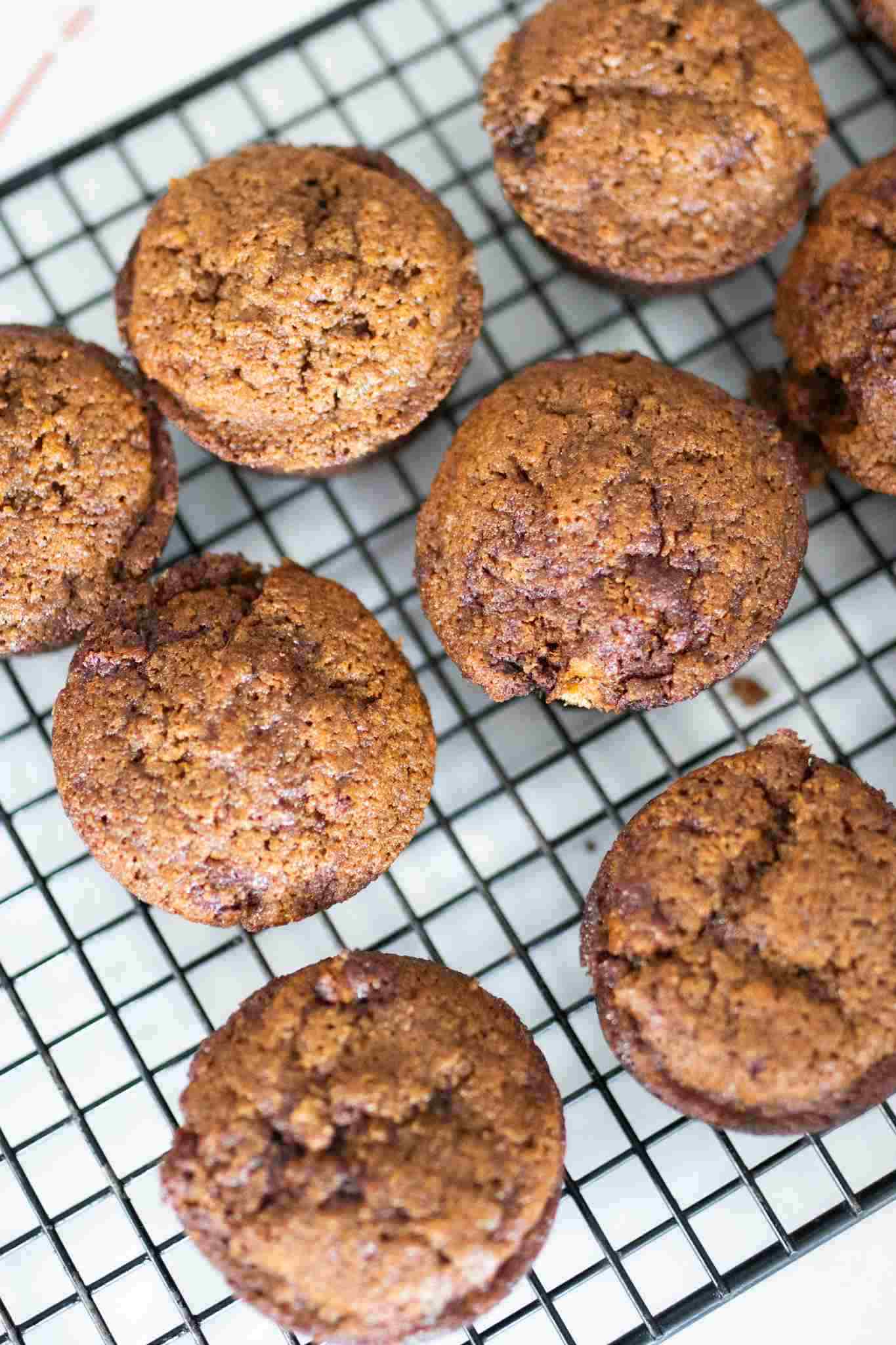 Overhead photo of fresh milled gingerbread muffins on a black wire rack.